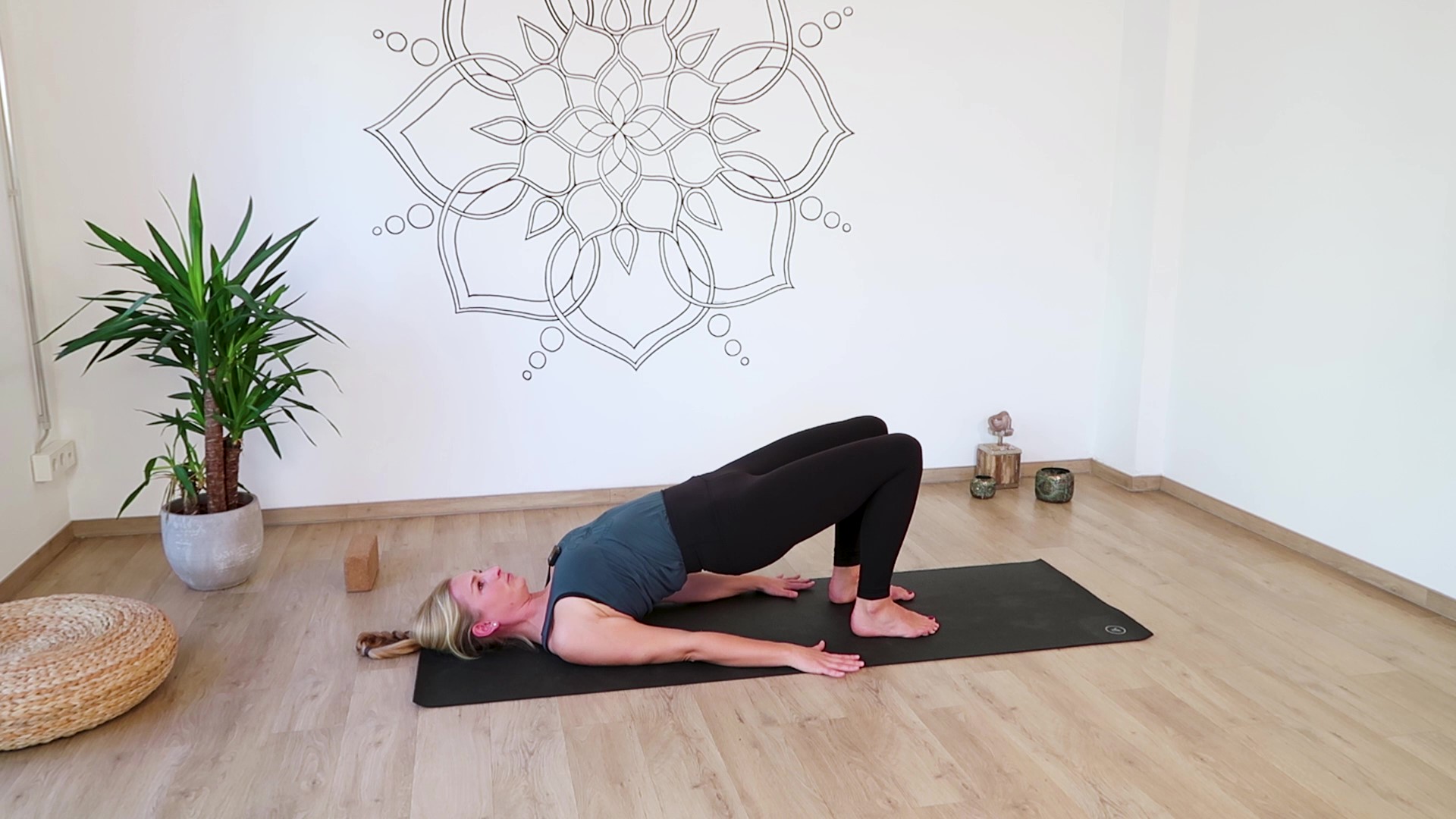 Schulterbrücke im Yoga mit Handflächen am Boden